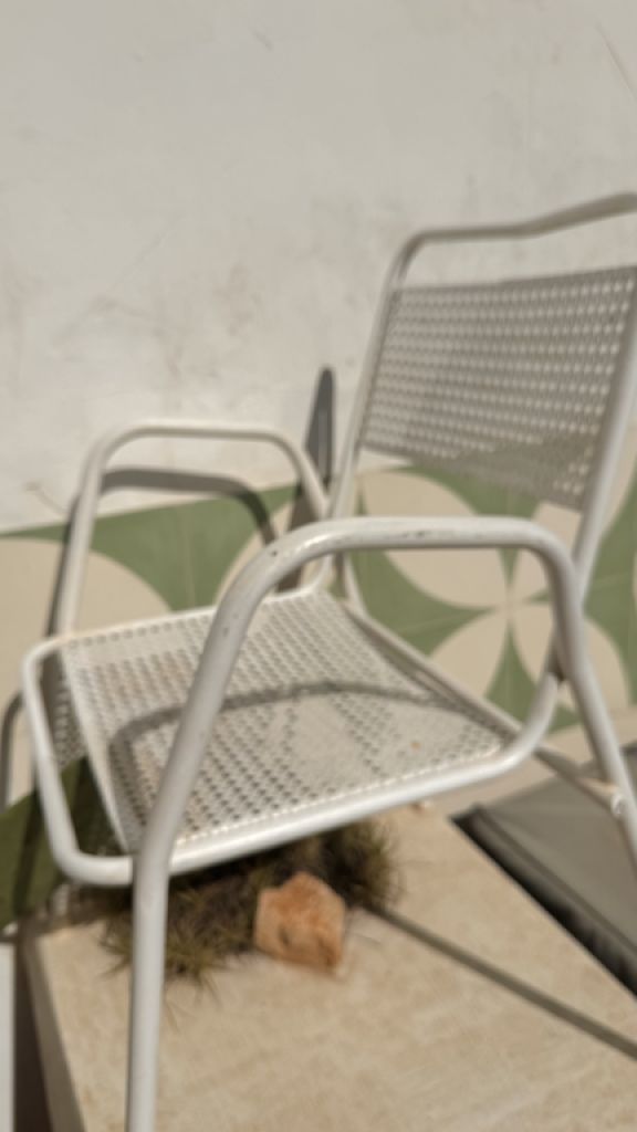 2 metal chairs with typical perforated sheet metal