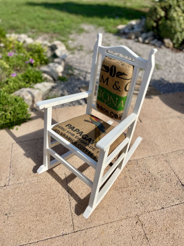 Dekorativer antiker Kinderschaukelstuhl mit Kaffeesack bezogen