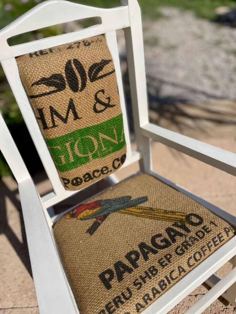 Dekorativer antiker Kinderschaukelstuhl mit Kaffeesack bezogen