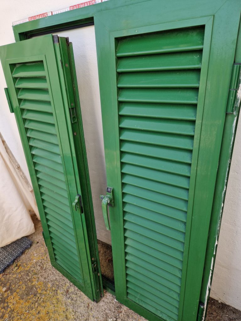 Persianas verdes (contraventanas) de aluminio.