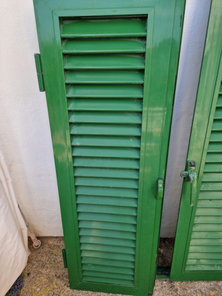 Persianas verdes (contraventanas) de aluminio.