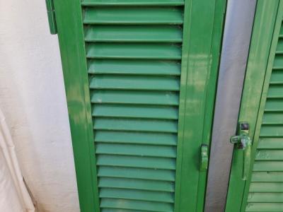 Persianas verdes (contraventanas) de aluminio.